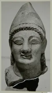 Limestone head of a figure with a tall pointed headdress, from Kition