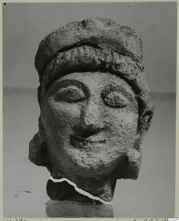 Limestone Cypro-Greek II head (K. 381 C.M.), a carved stone head with a close-fitting cap.
