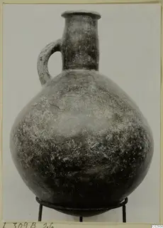 Red Polished III jug from Lapithos with one handle, standing on a wire stand