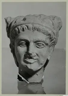 Sculpted stone head of a figure in a high headdress with curled locks over the brow, neck broken off, Kition