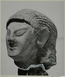 Limestone head statuette from Kition, shown in three-quarter view against a plain grey background