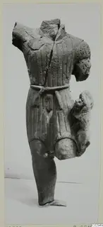 Headless limestone statue fragment of a male torso in a belted, pleated tunic, from Kition