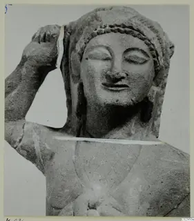 Limestone statuette of a female head and upper body, one arm raised to the head, from Kition.