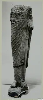 Limestone statue fragment from Kition: draped lower body and feet, with the head and right arm broken away.