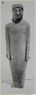 Grey limestone statue of a standing figure with a band around the head and arms held at its sides