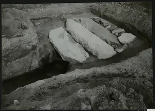 Excavation at Amathus with large pale stone slabs lying in a trench