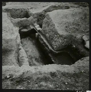 Excavation trench at Amathus with small squared stones lying along the edge of a cut.