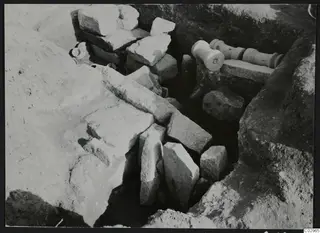 Excavation trench at Amathus, Tomb 16, with pale stone blocks and two column drums lying in the ground