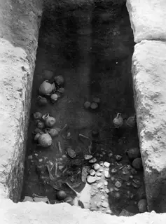 Finds in situ in Tomb 10 at Amathus: clusters of jugs and bowls and scattered bones on the floor of the tomb chamber