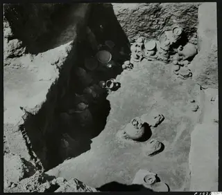 Excavation at Amathus with many pottery vessels lying in a trench and on a sloping floor