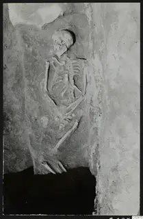 Roman skeleton in Tomb 16 at Amathus, lying against the tomb wall with the skull at upper left.