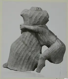 Limestone sculpture of a figure from Vouni, with one arm bent across the body and a ridged head covering