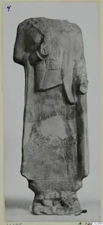 Headless limestone statue of a standing figure from Vouni, photographed frontally against a plain background.