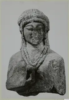 Limestone bust of a figure with a ridged headdress, downcast eyes and a two-strand necklace, from Vouni.