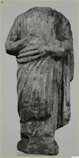 Headless limestone draped statue of a standing figure, arms folded across the body, from Vouni.