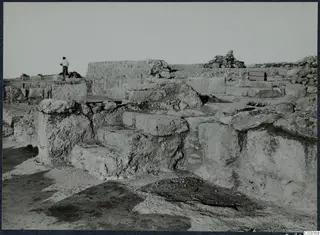 Excavated stone steps and walls at the palace at Vouni, with one standing person on the upper left.