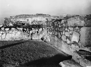 Ruined stone walls and a worn, sloping paved surface at the palace at Vouni