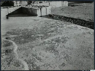 Large squared stone blocks forming a wall at the palace at Vouni, with rubble and worn ground in front