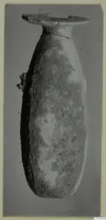 Alabaster vase from Cyprus with a long body, narrow neck and flat, disc-shaped mouth.