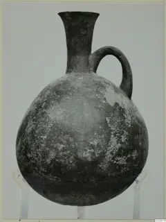 Black Slip Ware jug with a single loop handle and a tall flaring neck
