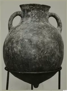 Two-handled Pottery Black Slip Ware jar on a metal stand