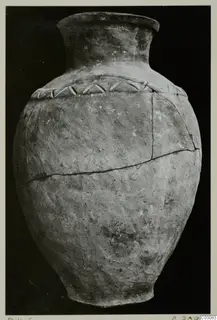 Pottery Plain White Hand-made Ware jar with a narrow neck and a band of slanted marks on the shoulder, against a black background
