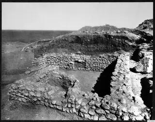 Excavated stone walls of a house at Mersinaki, with the sea visible to the left