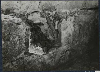 Excavated stone wall at the palace at Vouni, with a dark recess in the masonry