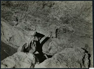 Excavated stones and a rough rock face at the palace at Vouni, seen close up.