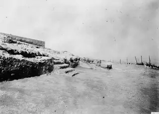 Ancient wall and worn stone steps at Vouni palace, with a wire fence along the right edge.
