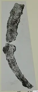 Two corroded iron objects from Marion Tomb 36, one straight and one curved, against a pale background.
