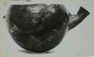 Pottery Red Polished III bowl from the Vrysi tou Barba tombs at Lapithos, seen from the side with a tubular spout
