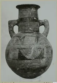 Pottery amphora with two handles and white incised linear decoration of bands and arcs.