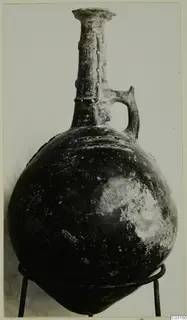 Pottery Red Polished II jug from Lapithos, Vrysi tou Barba tombs, photographed on a metal stand