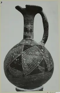 Pottery Red Polished II jug from Lapithos with a pinched spout, strap handle and incised hatched bands