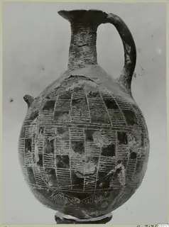Pottery jug with a tall neck, strap handle and incised hatched rectangles covering the globular body