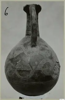 Pottery Red Polished II jug with a single strap handle and pale arc and band decoration