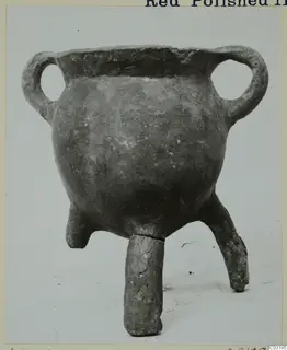 Pottery vessel with a rounded body, two loop handles and three short legs, from the Vrysi tou Barba tombs at Lapithos