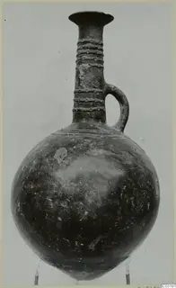 Pottery jug with a globular body, tall neck with raised ribbing, and a single loop handle