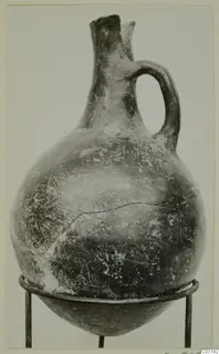 Pottery Red Polished I jug with a single handle and pinched spout, from the Vrysi tou Barba tombs at Lapithos