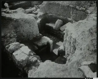 Excavation at Amathus with pale stone blocks and a low stacked stone structure in a trench