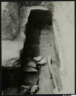 Tomb 8 at Amathus, upper layer: stone slabs step down toward a dark tomb opening in a cut passage