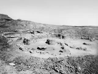Excavated stone foundations of Houses IV and V at Kythrea, with bare ground and hills behind