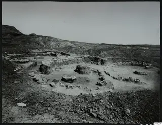 Excavated stone house foundations at Kythrea, with low walls and round stone bases on a stony hillside.