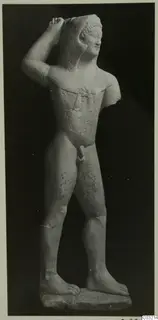 Limestone statue of a standing nude male figure from Kition, one arm raised to the head