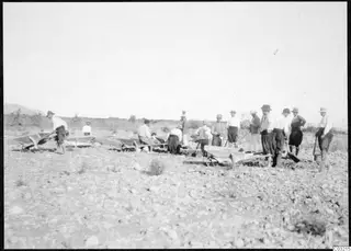 Workers with wheelbarrows digging in a stony field at Soli, Ibrahim's field
