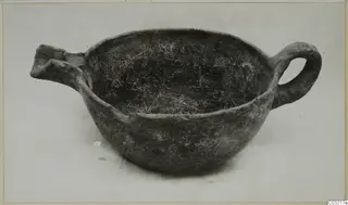 Pottery Red Polished III bowl from Ayios Iakovos with a loop handle on one side and a broken spout on the other.