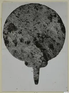Corroded flat metal plaque with a short tang, from Marion Tomb 46