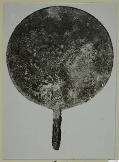 Corroded round metal disc with a narrow tang at the bottom, from Marion