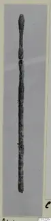 Bronze toilet-requisite: a slender, dark rod with a rounded top end, shown upright